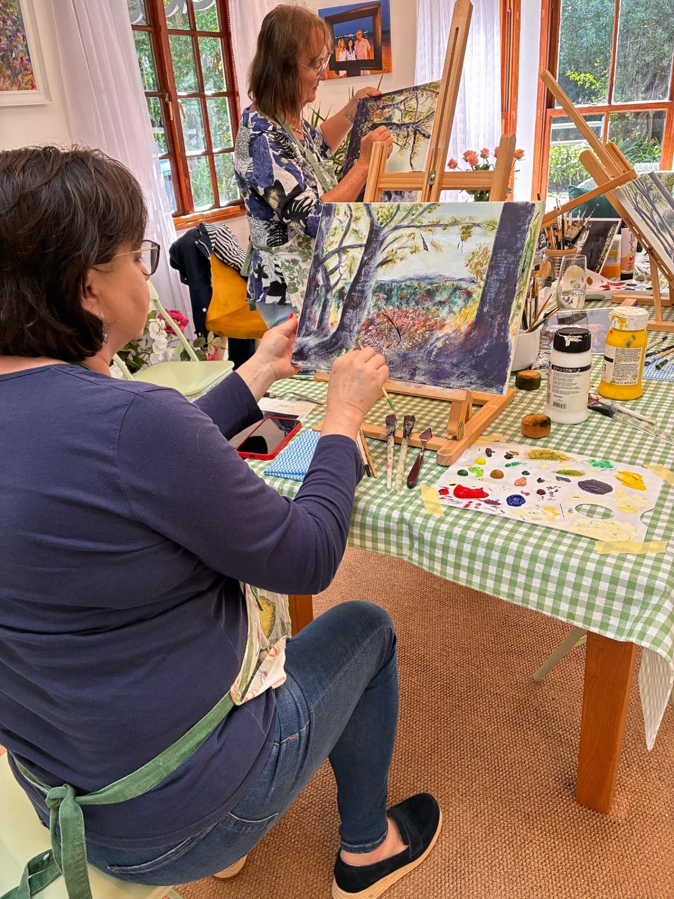 Two students painting trees in the studio