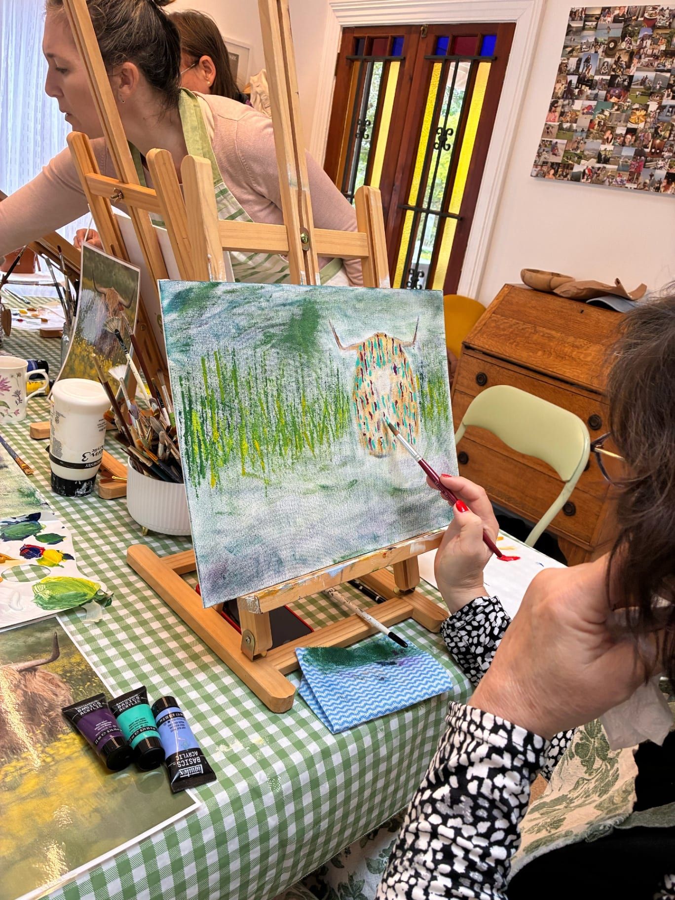 Student painting a Highland cow on canvas